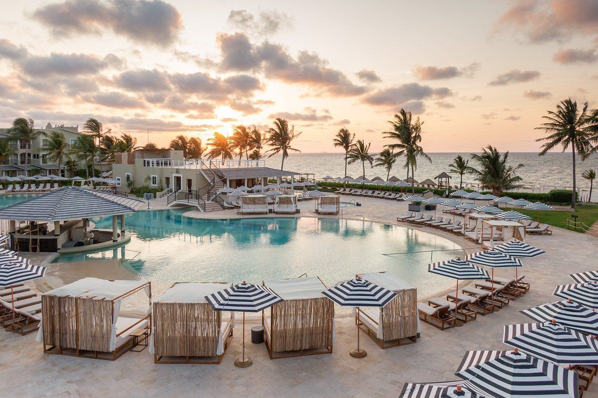 Image of the pool at the Hyatt Zilara Riviera Maya with the beach and sunset in the background