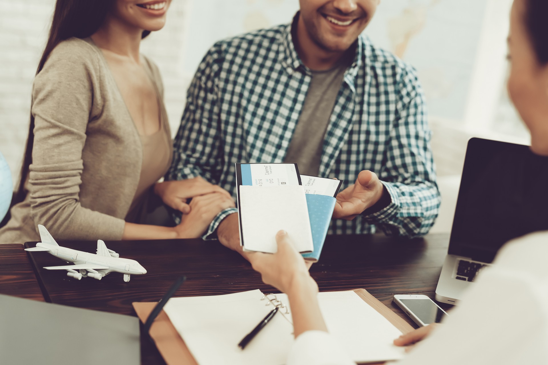 Manager in Travel Agency Giving Tickets To Couple.